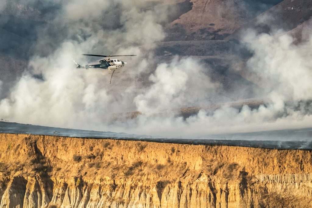 A helicopter is flying over a large cliff